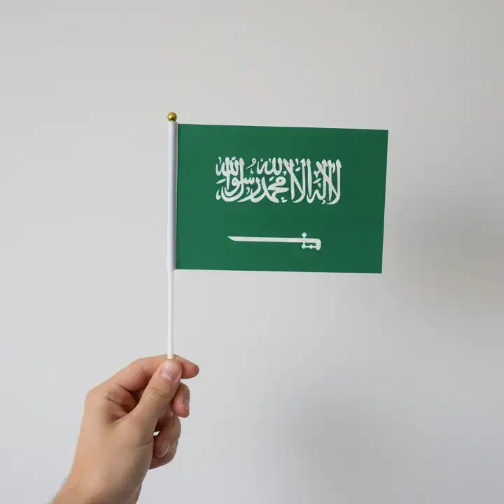 مجموعة من أعلام السعودية الصغيرة المحمولة باليد جاهزة للتوزيع في المدارس والشركات